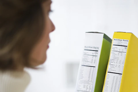 Kobieta czytająca etykiety na produktach spożywczych.